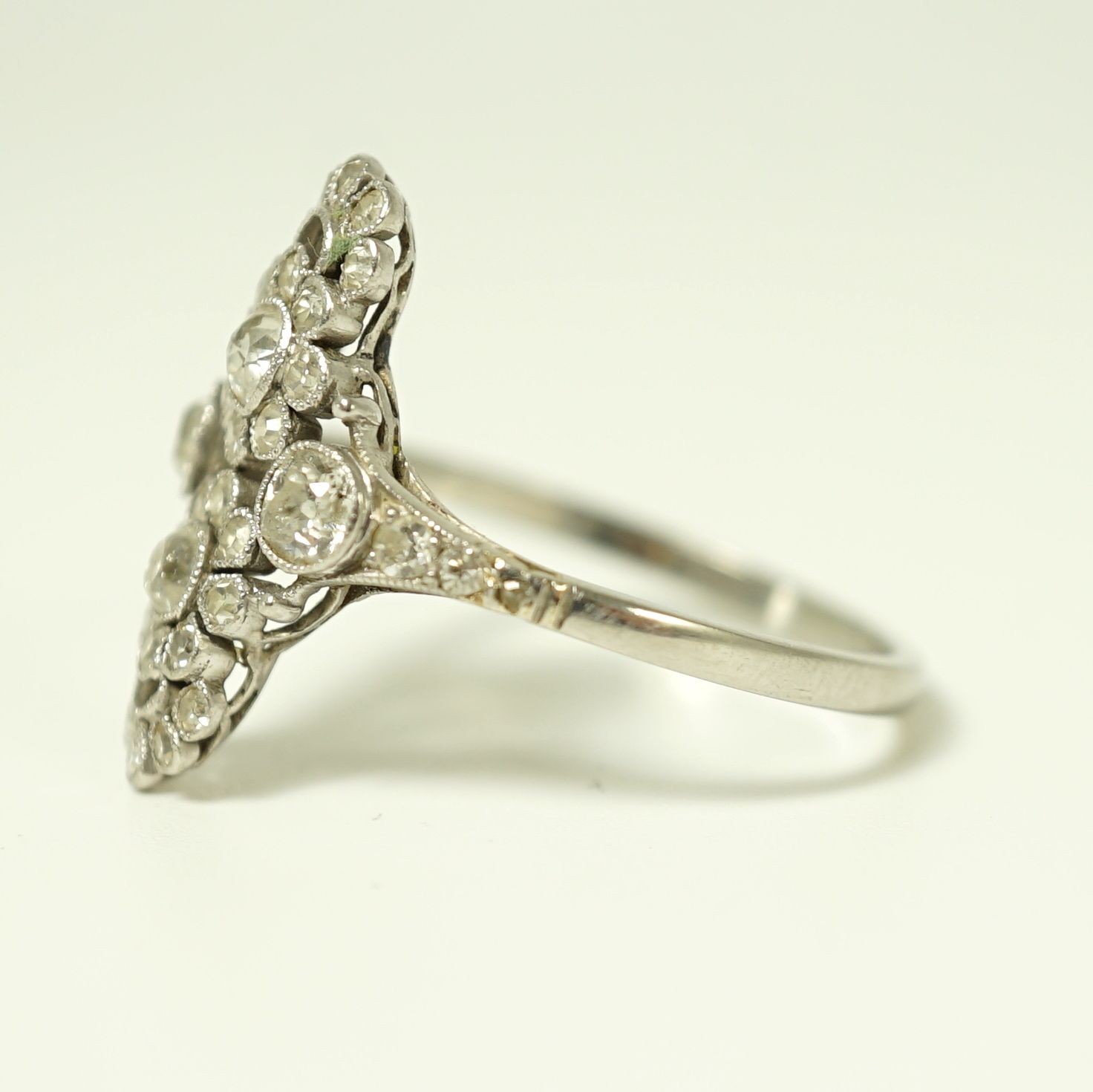 A 1920's platinum and millegrain diamond set flower head cluster upfinger ring